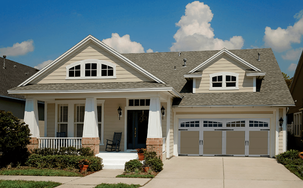 Home with tan two-car Coachman Collection garage door