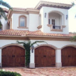 Florida home with three wooden signature series garage doors